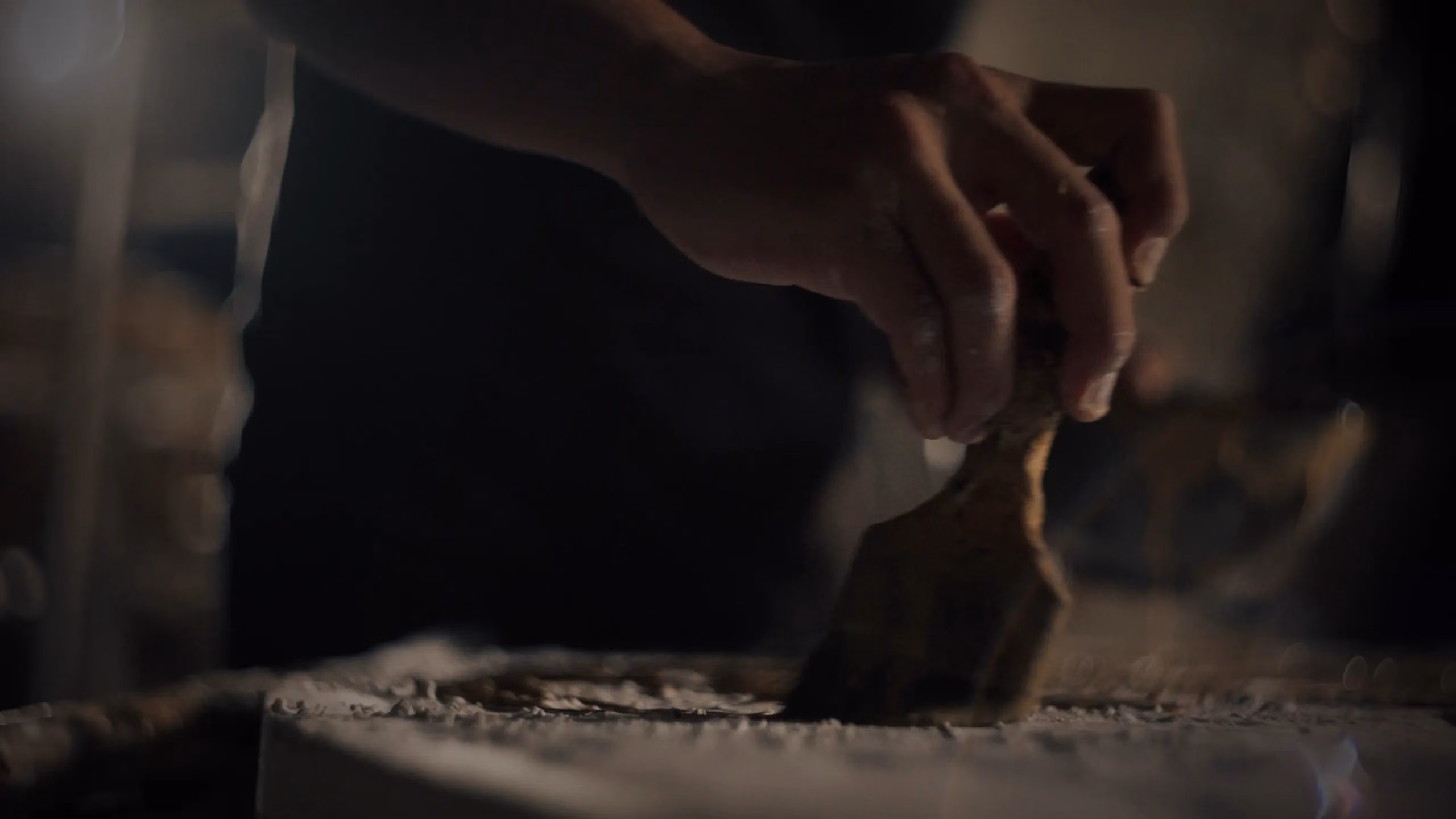 Craftsman shaping a brass sculpture by hand